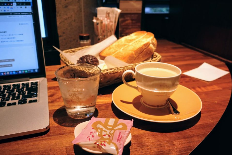 コメダ珈琲の机の上にある前に水とミルクコーヒーと奥にある小倉トースト