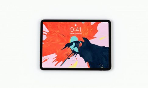 iPadPro2018が横向きで中央にあり、オレンジと水色と黒が飛びちり合わさった壁紙になっている